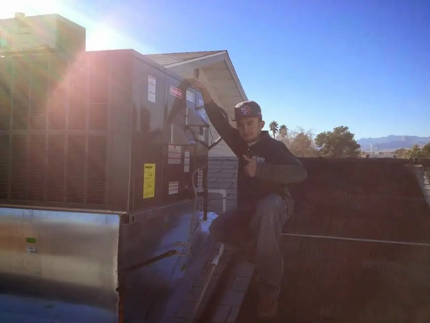 HVAC technician performing AC Tune-Up on a rooftop unit in Ridge Wood Heights